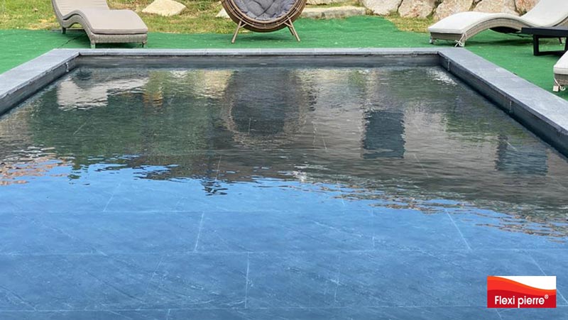 Feuille de pierre en piscine - Vue d'une piscine dans le Sud de la France avec le fond mobile de piscine relevé pour affleurer l'eau.<br>Feuilles de pierre Noir Stellaire